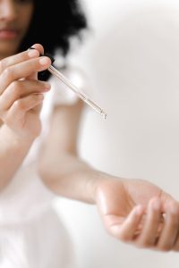 woman applying essential oil to wrist