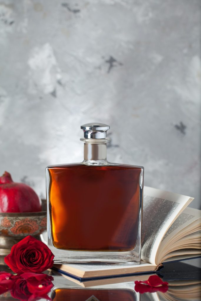 bottle of perfume with roses and a book